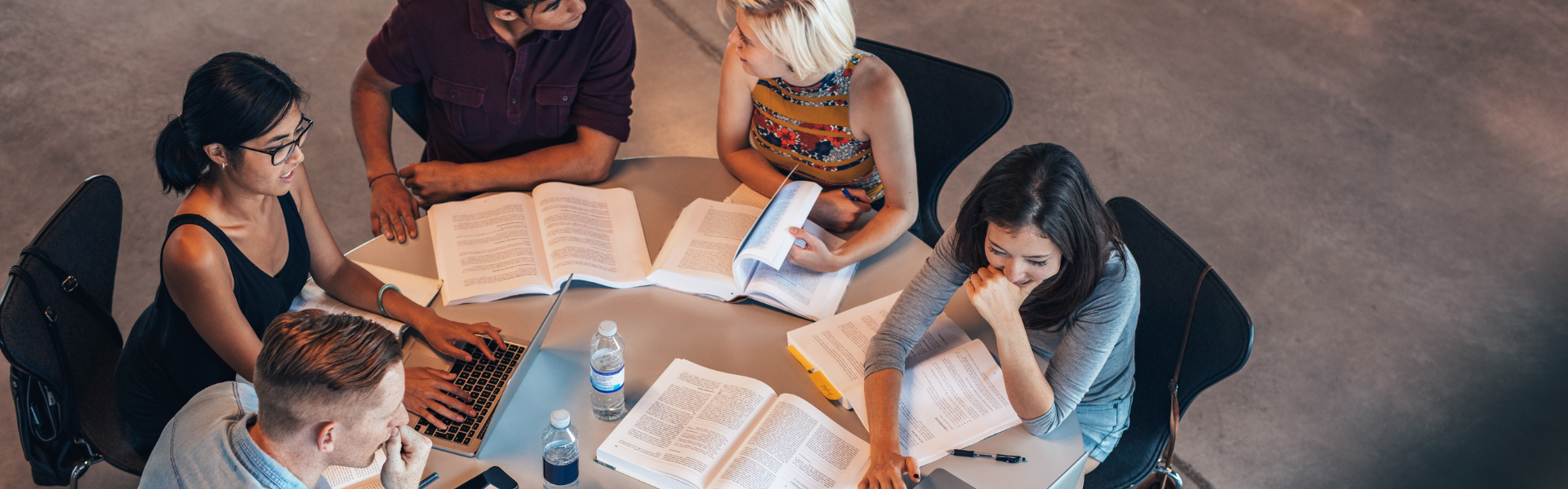 Studenter runt ett bord som pluggar.
