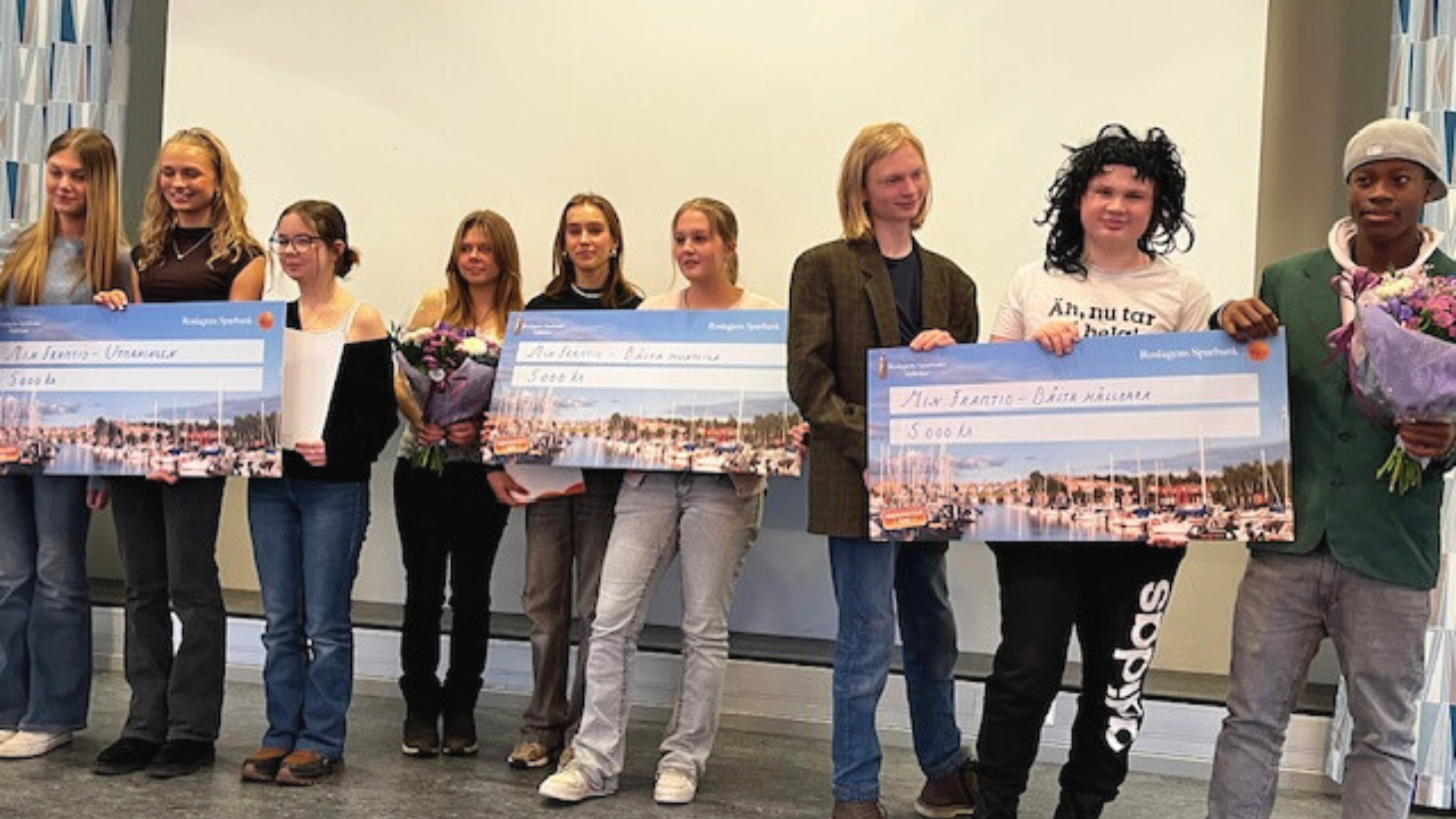 Niondeklassare poserar med stora vinstcheckar från Min Framtid.