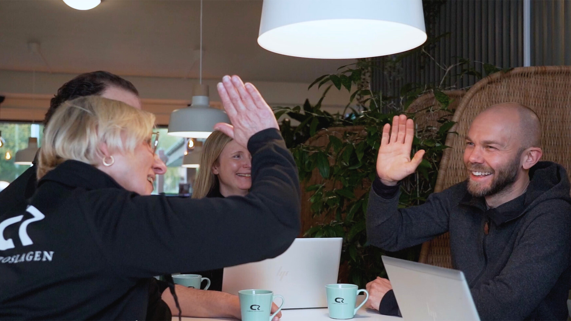 Annie och en man high fivar glatt.